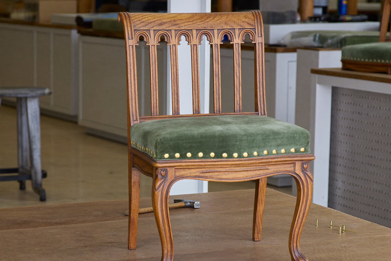 Antiker Stuhl mit neuem grünem Samtbezug im Atelier